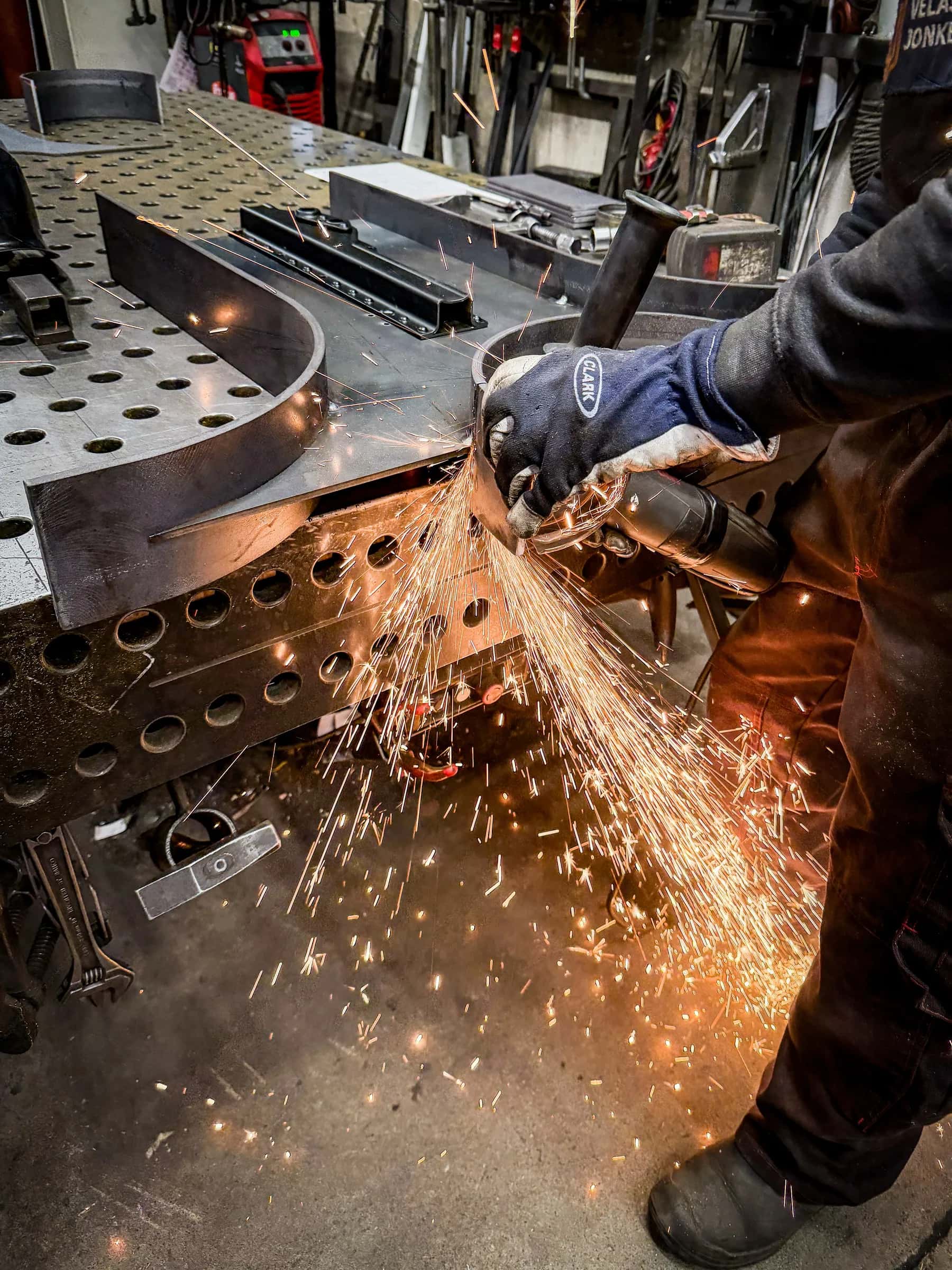 Grinding a steel plate with a shower of sparks in the workshop