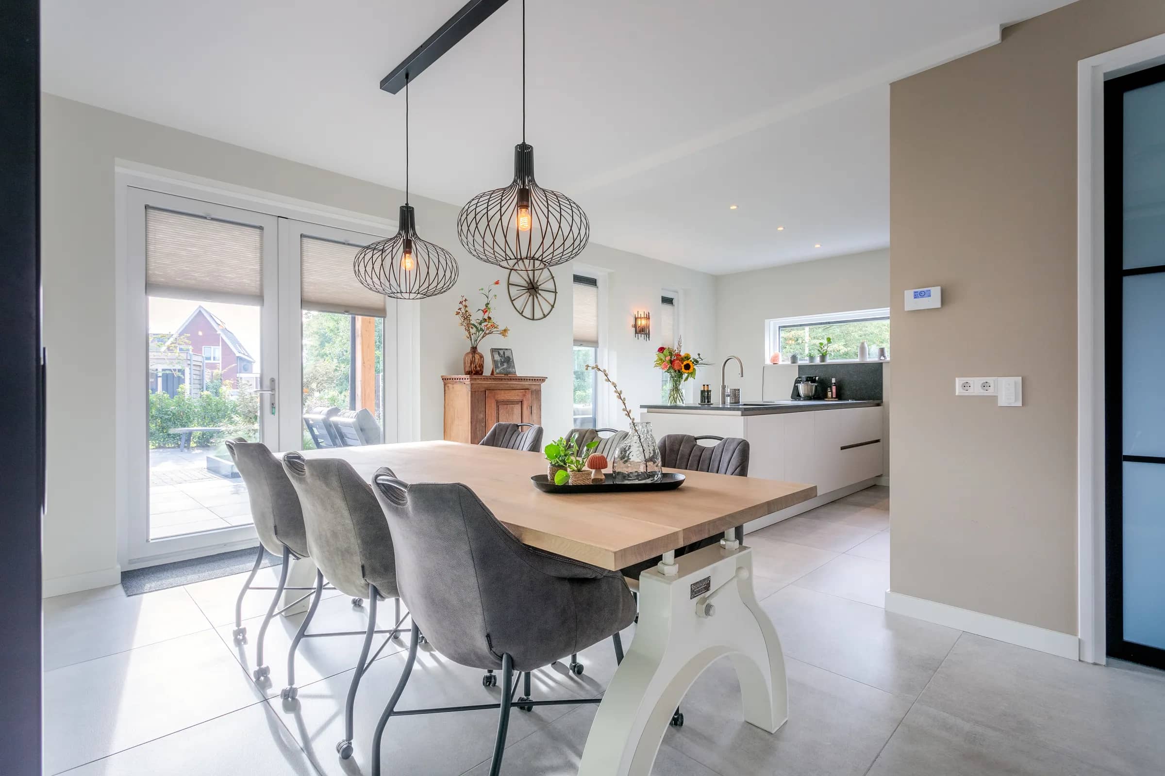 Full view of the oak dining table with chairs on a white steel column base in the Loosman family home