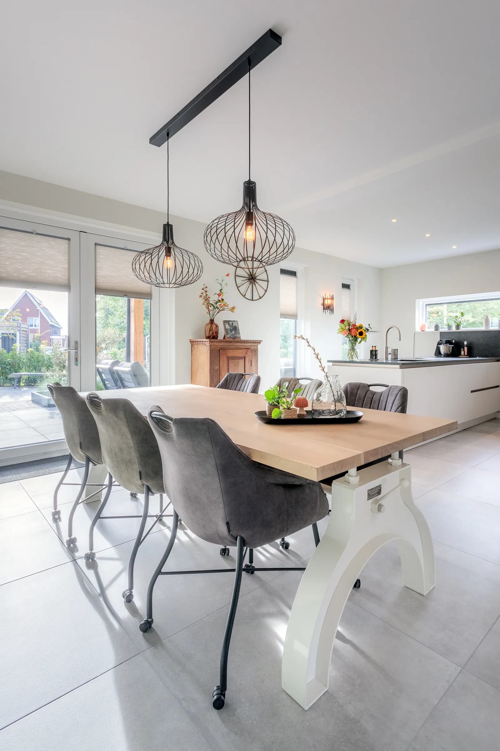 Oak dining table on a white steel column base looking towards the kitchen in the Loosman family home