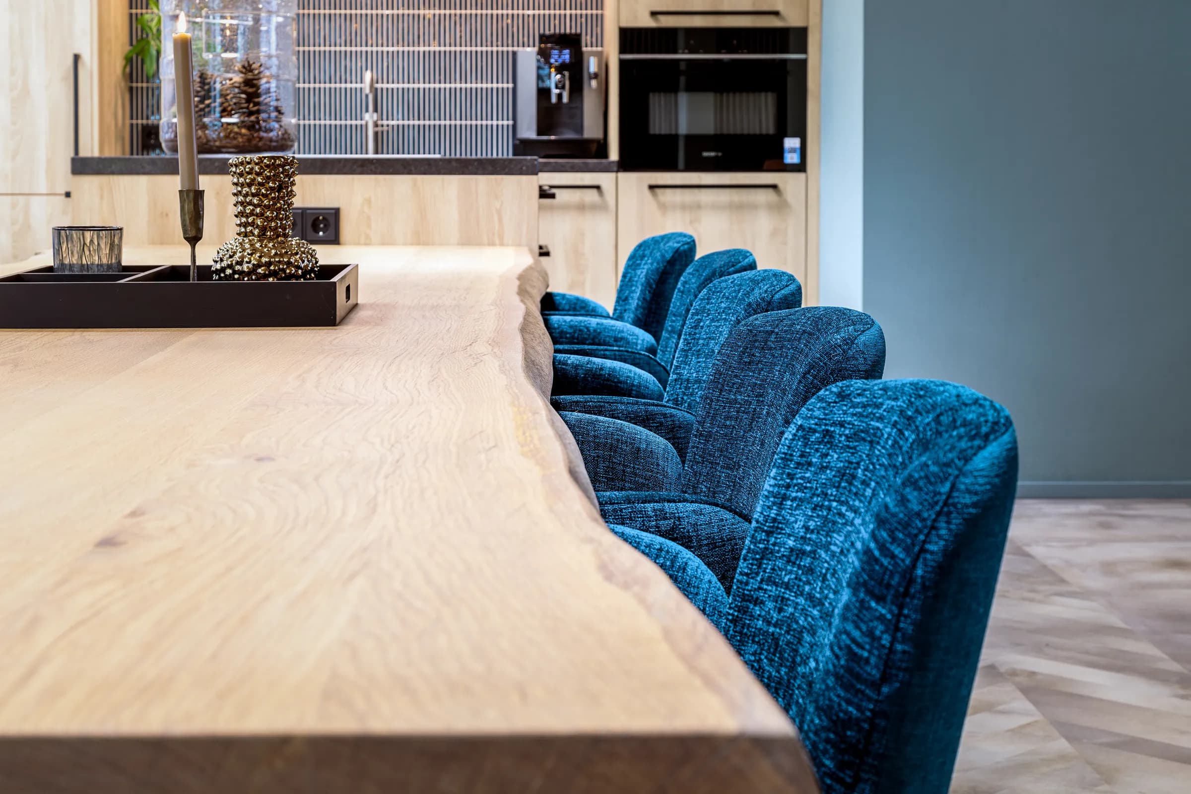 Close-up of the table top with blue chairs looking towards the kitchen at Wiz Arts