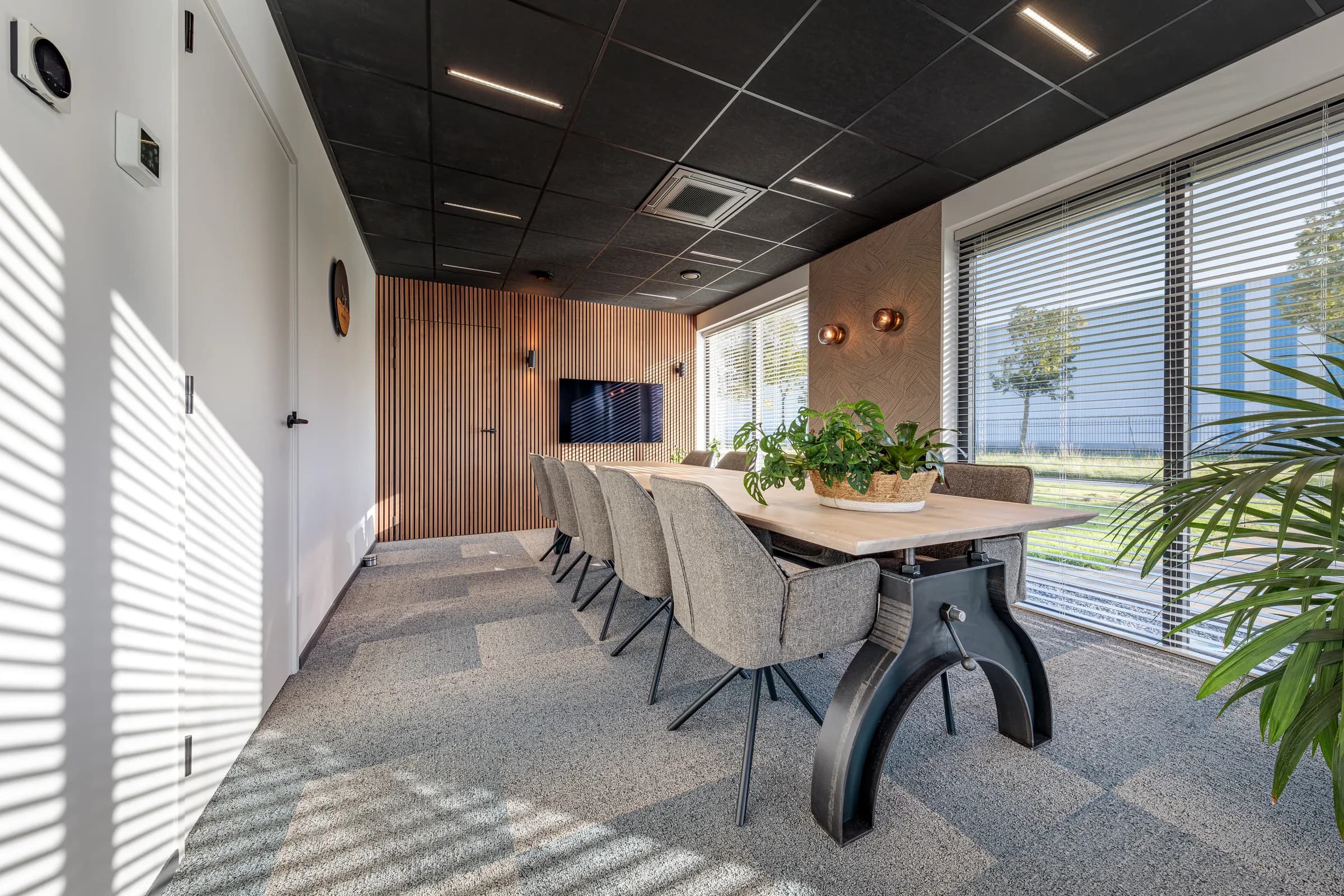 Light oak conference table and its cast iron column base in the Advies en Kies office
